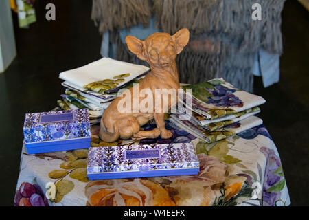 Interior of a shop selling a hand-crafted ceramic dog surrounded by lavender soaps and other souvenirs in a gift shop in Siena, Italy Stock Photo