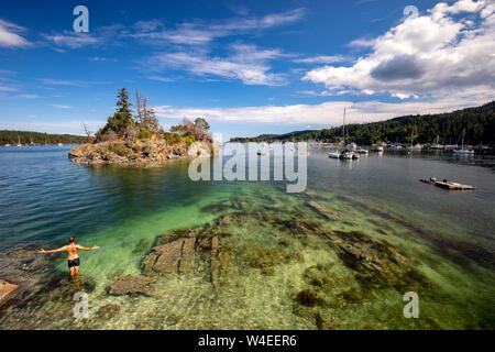 Person swimming near Grace Islet in Ganges Harbour - Salt Spring Island, British Columbia, Canada Stock Photo