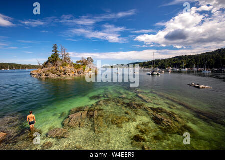 Person swimming near Grace Islet in Ganges Harbour - Salt Spring Island, British Columbia, Canada Stock Photo