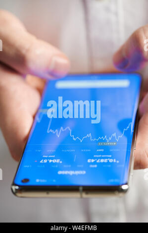 New york, USA - july 22, 2019: Checking bitcoin price on mobile app close up view, smartphone in hands Stock Photo