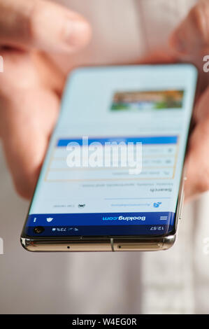 New york, USA - july 22, 2019: Using booking mobile app close up view, smartphone in hands Stock Photo