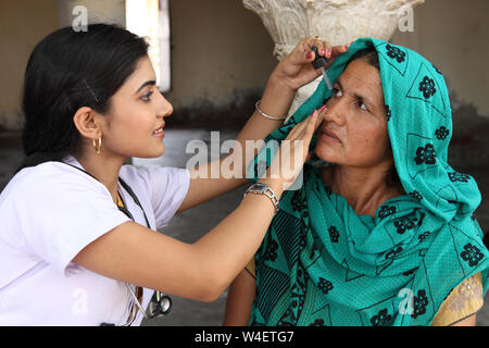 Female doctor putting eye drops in a patient eye Stock Photo