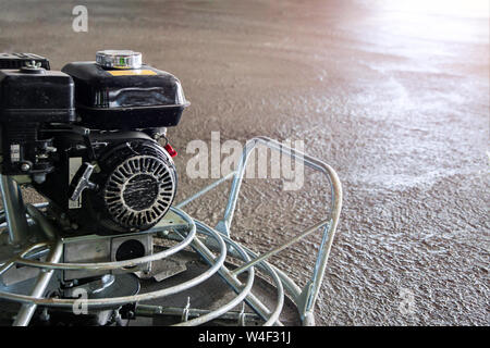 Power float grinder machine on wet concrete background closeup shot with selective focus and boke blur. Stock Photo