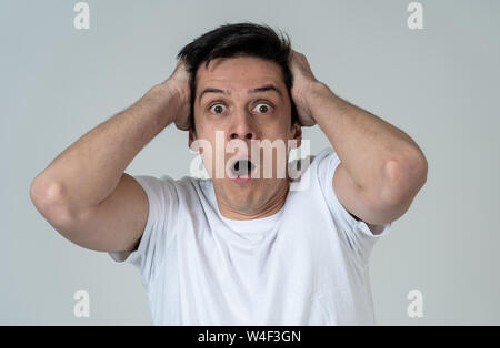 Young man feeling scared and shocked making fear, anxiety gestures. Looking terrified and desperate trying to cover himself. Portrait with copy space. Stock Photo