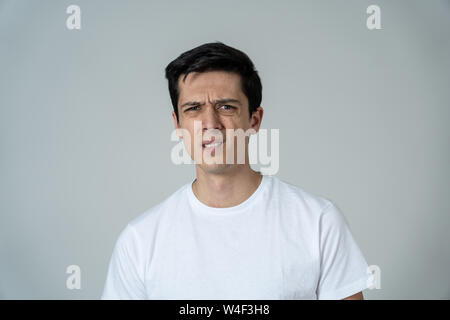 Young man feeling scared and shocked making fear, anxiety gestures. Looking terrified and desperate trying to cover himself. Portrait with copy space. Stock Photo