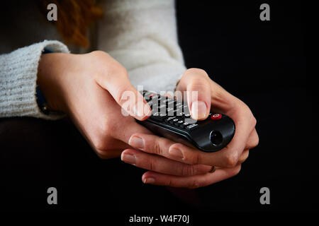 Close-up image of two female hands with remote control pointing forward Stock Photo