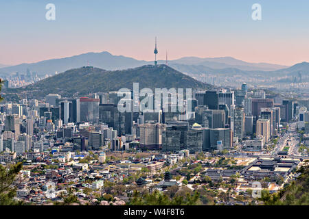 The Namsan tower, surrounded by modern skyscrapers and ancient temple and houses in central Seoul, South Korea Stock Photo