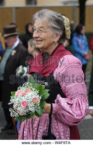 A woman in a traditional Bavarian dirndl dress takes part in the Oktoberfest parade in Munich Germany Stock Photo
