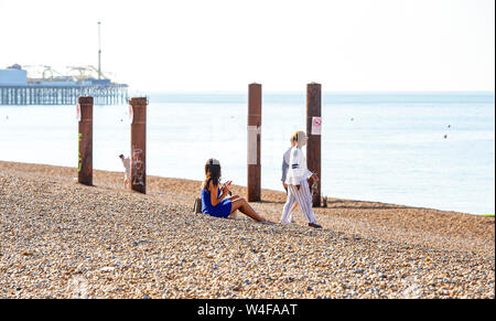 Brighton UK 23rd July 2019 - Visitors enjoy the early morning hot sunshine by the West Pier in Brighton . Heatwave conditions are forecast for the South East of Britain with temperatures expected to reach the mid thirties today and over the next few days . Credit: Simon Dack / Alamy Live News Stock Photo