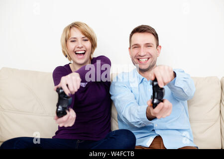 Happy young couple playing video games at home. Stock Photo