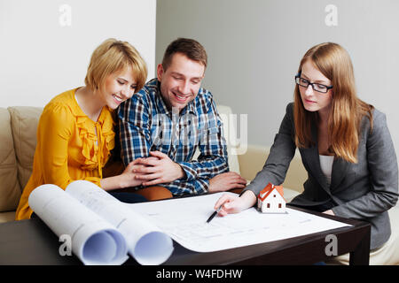 Young couple discussing the blueprints with an architect Stock Photo