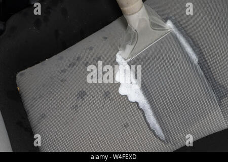 Dry cleaning salon cars. Worker uses washing vacuum in the car Stock Photo