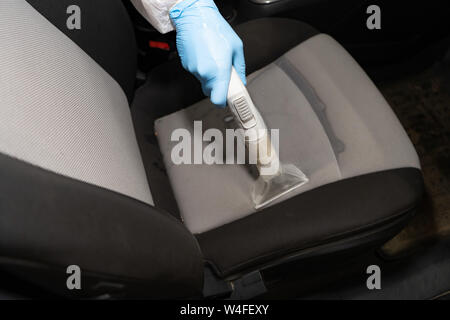 Dry cleaning salon cars. Worker uses washing vacuum in the car Stock Photo