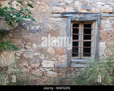 Old abandoned stone mansion with bars on the window. Stock Photo