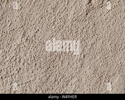 Textured grinded plaster in dark beige. Background or texture seamless pattern. Stock Photo