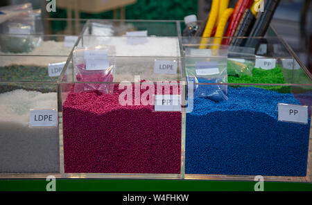 Colorful of dyed plastic polymer granules in containers Stock Photo