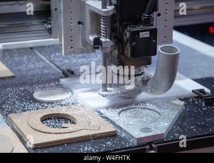 CNC Laser engraving machine carving alphabet on plastic plate Stock Photo