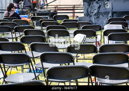Empty rows of folding chairs at the end of a concert. Stock Photo