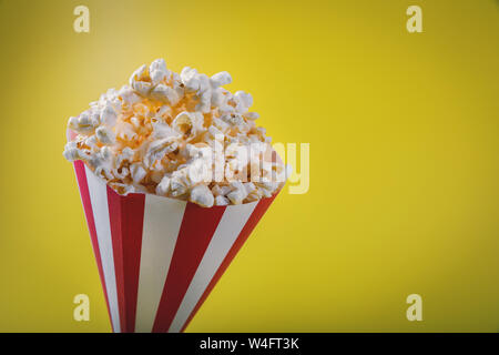 striped pop corn bag on yellow background with copy space Stock Photo