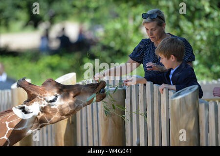 Sophie, Countess of Wessex, and her son James, Viscount Severn, feeding a giraffe during a visit to Bear Wood at Wild Place Project in Bristol. Stock Photo