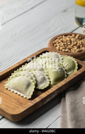 selective focus of green raw ravioli with flour on wooden board Stock ...