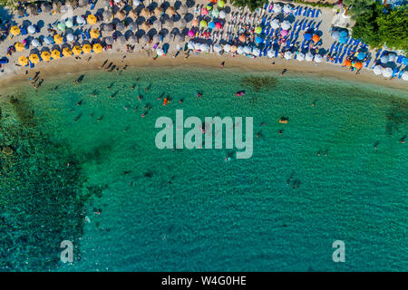 Aerial View of the Aliki Beach with colorful umbrellas, at Thassos island, Greece. swimming people in sea Stock Photo