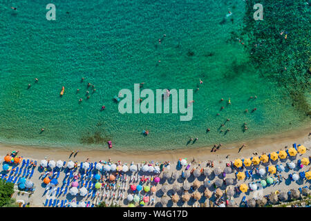 Aerial View of the Aliki Beach with colorful umbrellas, at Thassos island, Greece. swimming people in sea Stock Photo