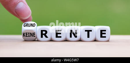 Hand turns a dice and changes the German expression "keine Rente" ("no pension" in English) to "Grundrente" ("basic pension" in English). Stock Photo