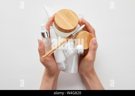 cropped view of woman hands with cosmetics in tubes, dispensers, bottles and jar isolated on white Stock Photo