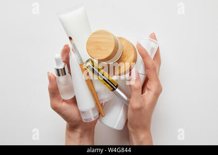 cropped view of woman hands with cosmetics in tubes, dispensers, bottles and jar isolated on white Stock Photo