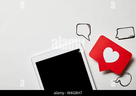 digital tablet with paper like sign, thought and speech bubbles on white surface Stock Photo