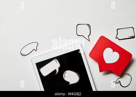 digital tablet with paper like sign, thought and speech bubbles on white surface Stock Photo