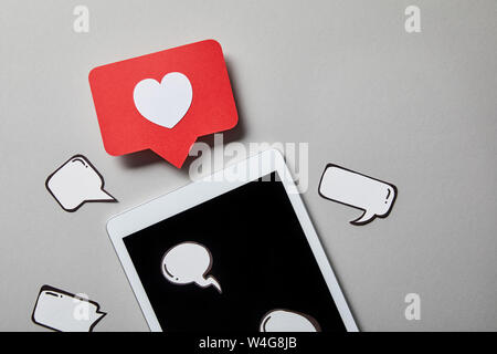 digital tablet with paper like sign, thought and speech bubbles on white surface Stock Photo
