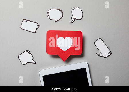 digital tablet with paper like sign, thought and speech bubbles on white surface Stock Photo