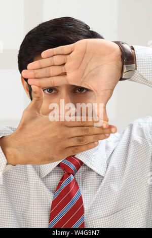 Businessman framing face with fingers Stock Photo