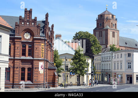 10 July 2019, Mecklenburg-Western Pomerania, Wolgast: View of the tower of the city church St. Petri von Wolgast, on the left the former imperial post office, which has been used as a hostel since 2013. Built in the 14th century as a large three-nave basilica, the church towers above the houses of the town in Eastern Pomerania. The town on the Peene river to the island of Usedom has around 13,000 inhabitants. In 1282 the town was granted the town charter according to the Lübeck model. Photo: Stefan Sauer/dpa-Zentralbild/ZB Stock Photo