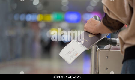 Closeup of girl  holding passports and boarding pass at airport Stock Photo