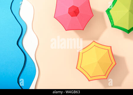 top view of paper beach with summer umbrellas on sand near ocean Stock Photo