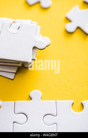 selective focus of connected and incomplete puzzle pieces on yellow Stock Photo