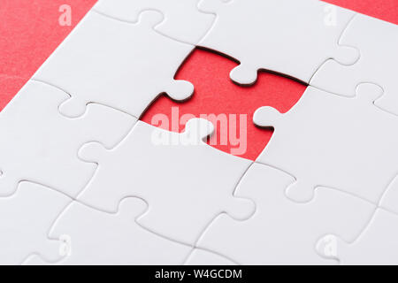 selective focus of white incomplete jigsaw on red Stock Photo