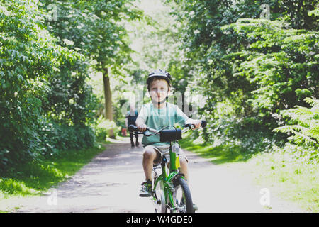 Portrait of proud little boy learning to ride bicycle Stock Photo