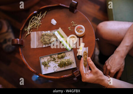 Close-up of a hands rolling a joint of marijuana from above Stock Photo