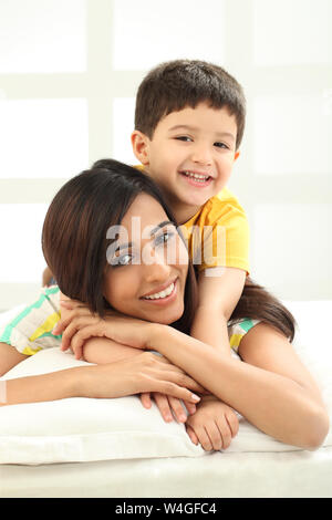 Boy hugging mother from behind at home Stock Photo