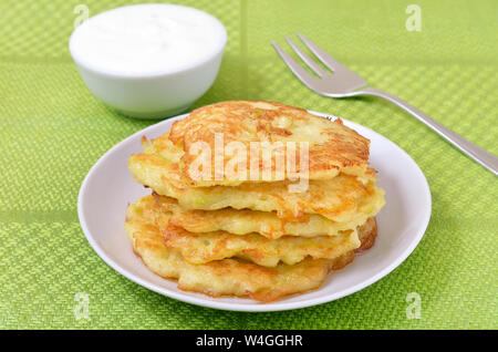 Fried courgette pancakes on white plate Stock Photo