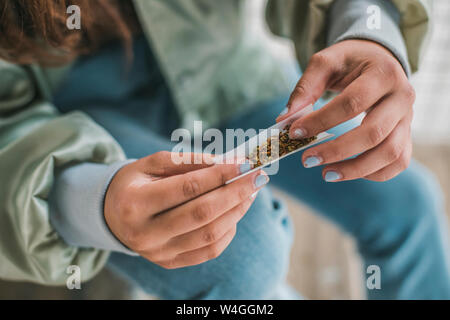 Woman's hands rolling a Marihuana joint, close-up Stock Photo