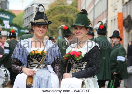 Two ladies in traditional tracht pose for the camera at the start of the Oktoberfest parade in Munich, Germany Stock Photo