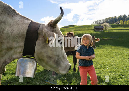 Girl with cows on pasture Stock Photo