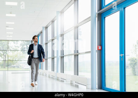 Young businessman walking in a passageway Stock Photo