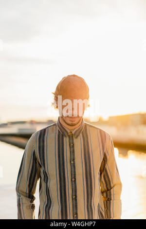Man wearing baseball cap at sunset Stock Photo