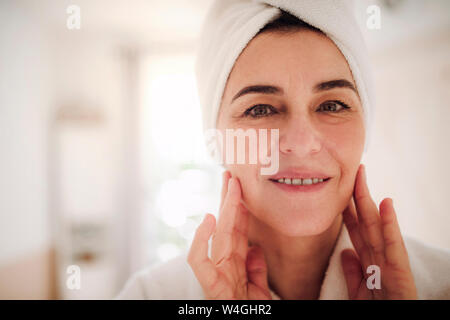 Portrait of smiling mature woman in a bathroom at home Stock Photo